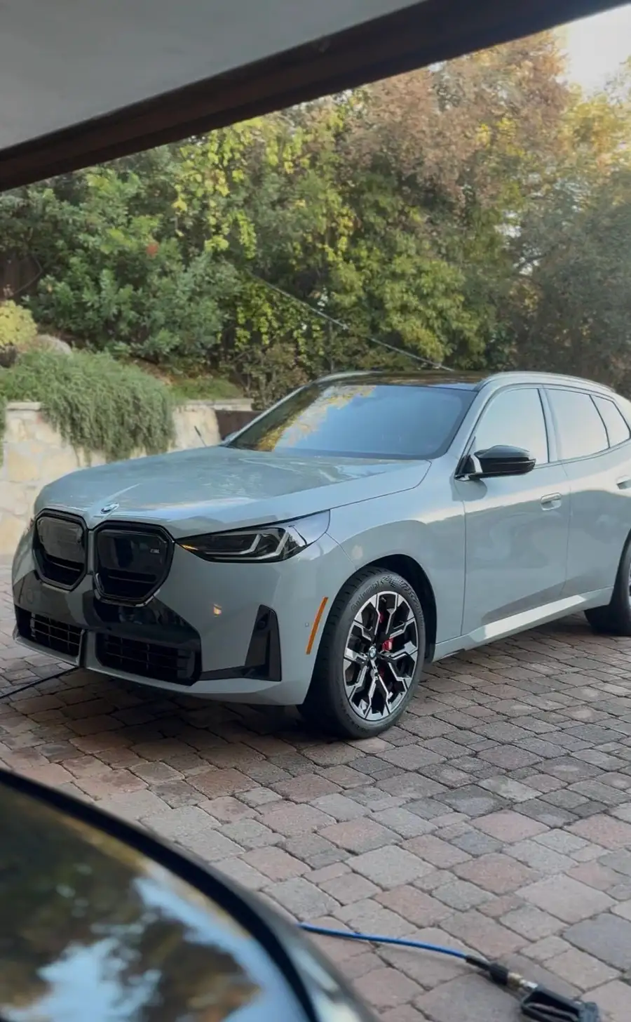 Grey BMW SUV on a paver driveway